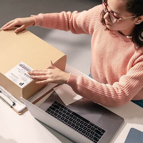 Woman packs up a product to ship potentially to a buyer from OfferUp.